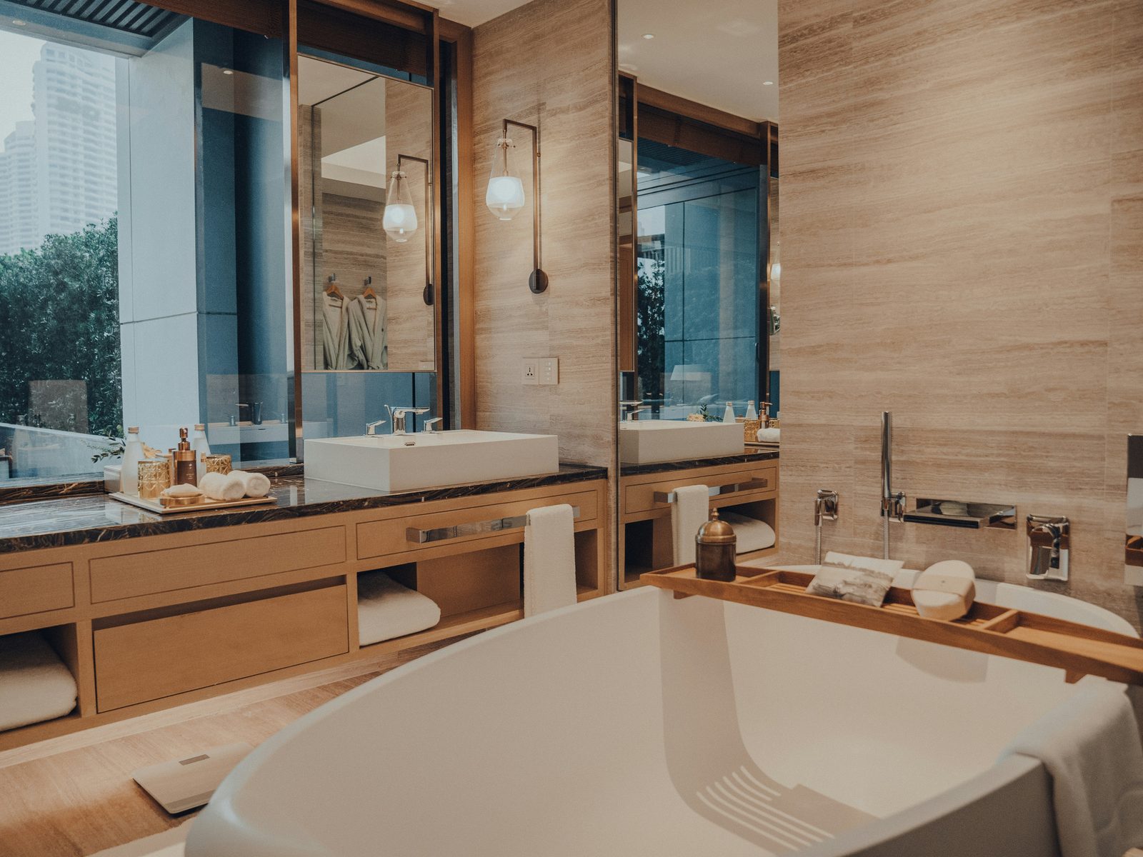 Hotel bathroom with timber panelling, a double vanity and a freestanding bath