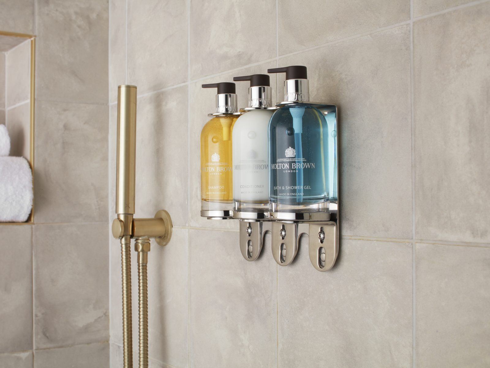 Molton Brown Luxury collection wall-mounted in a stone-tiled hotel bathroom