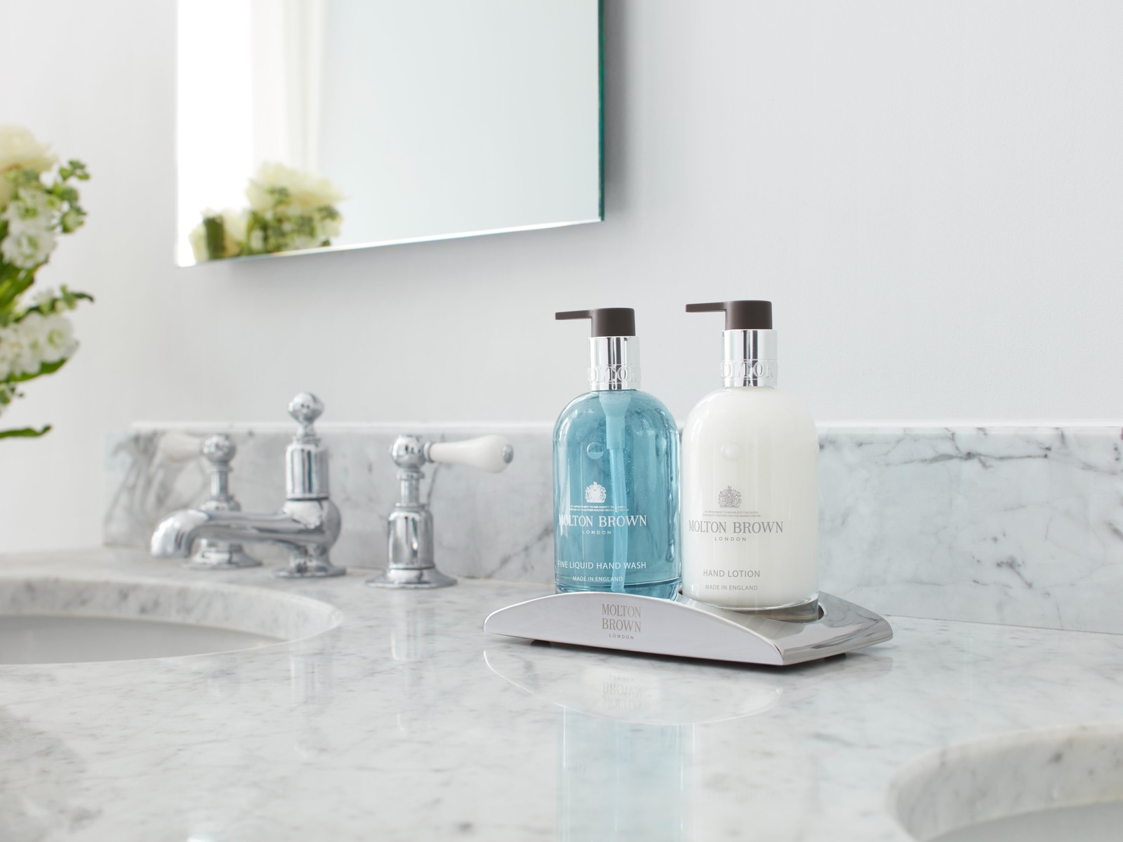 Molton Brown fine liquid hand wash and hand lotion on a branded chrome tray, on a Carrara marble vanity