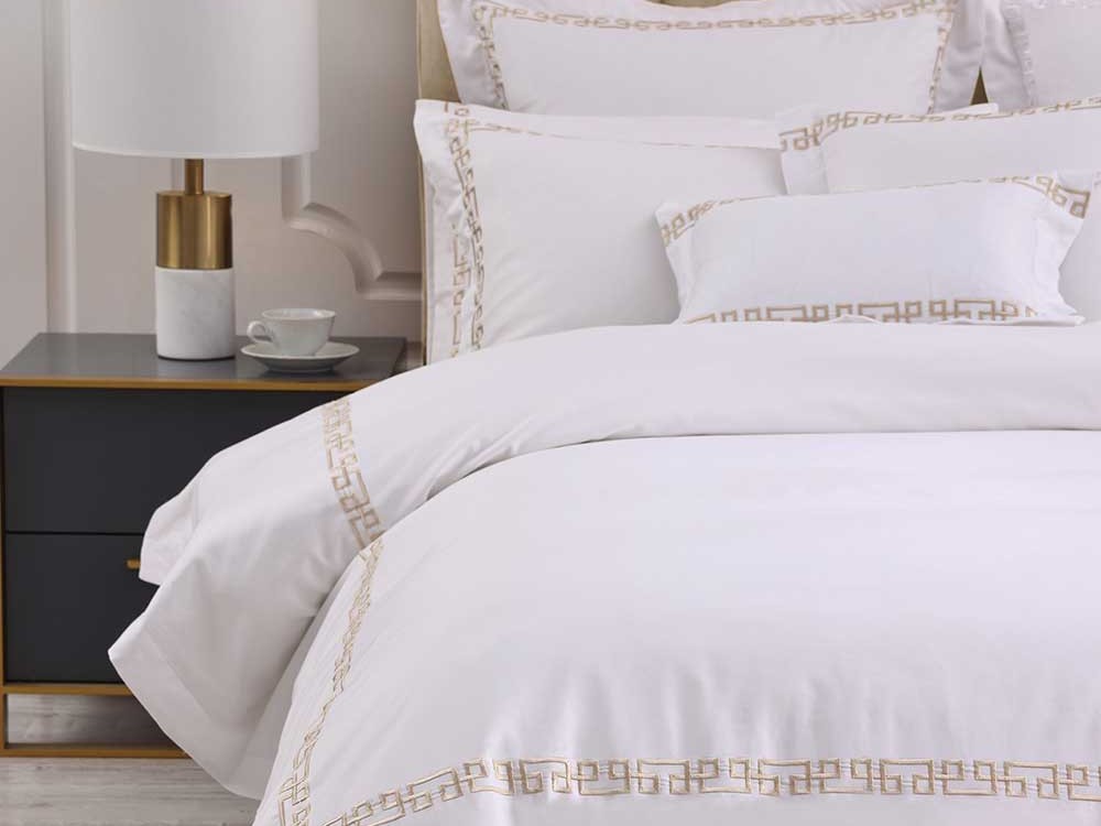 Muir Ares bedding with a champagne geometric embroidered border