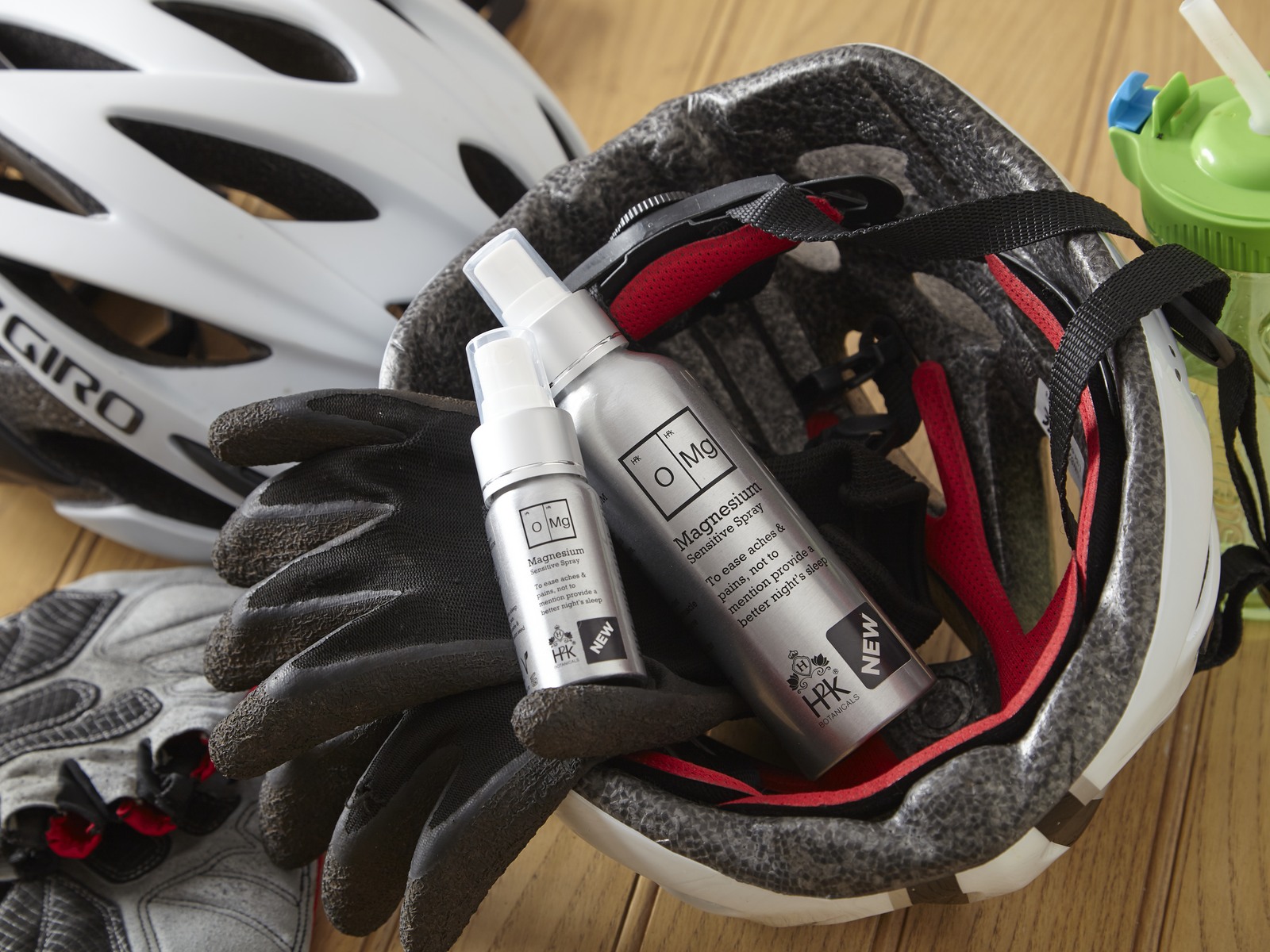 Two sizes of OMG Magnesium Sensitive Spray with a cycling helmet and gloves