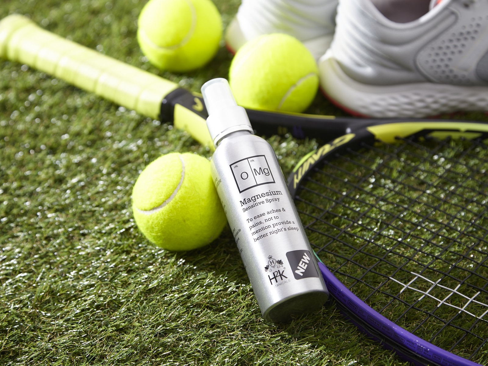 OMG Magnesium Sensitive Spray on a court beside a racket and tennis balls