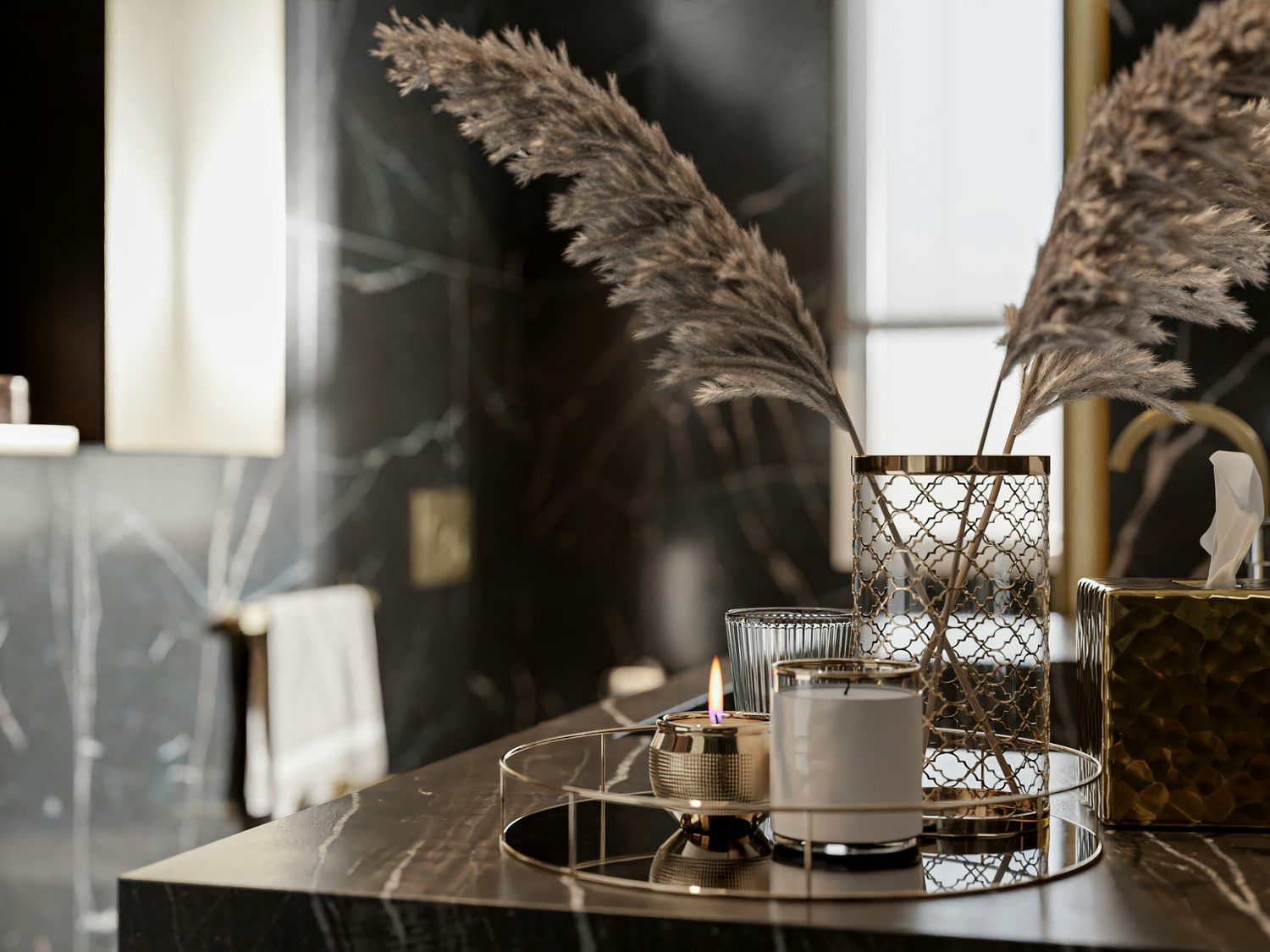 Lit candle and brass accessories on a black marble hotel vanity