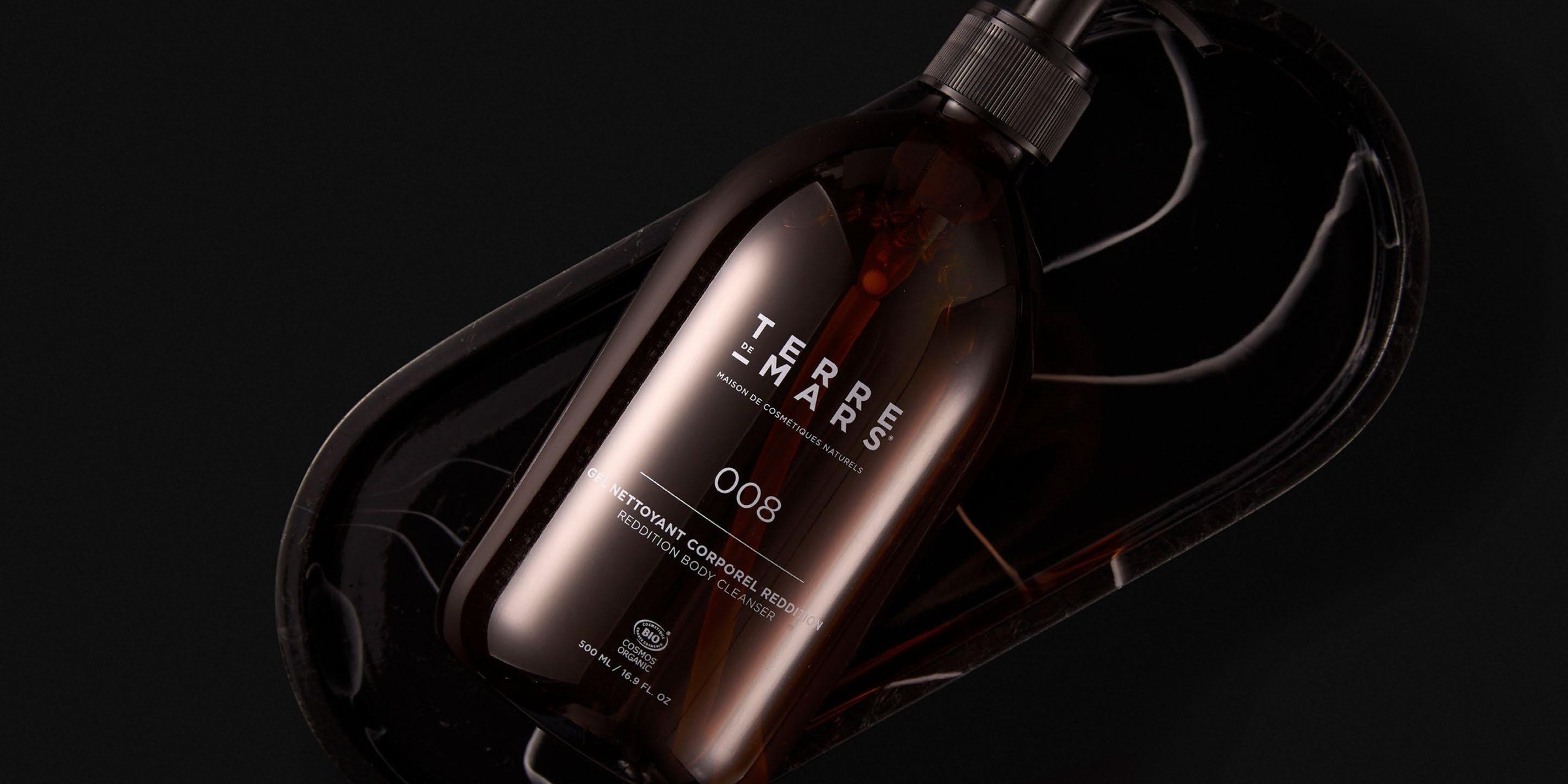 Terre de Mars body cleanser in a dark stone dish